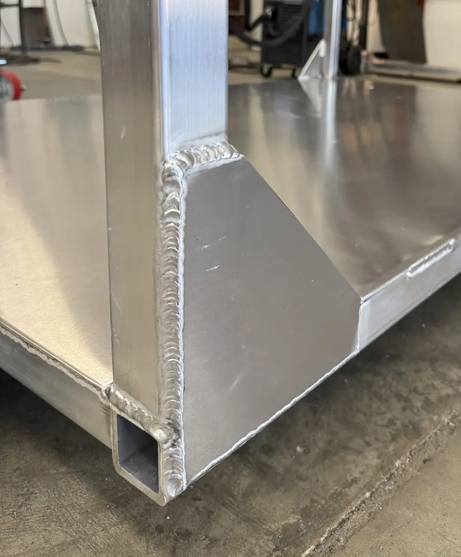 Welded corner post and gusset at the base of an aluminum cart