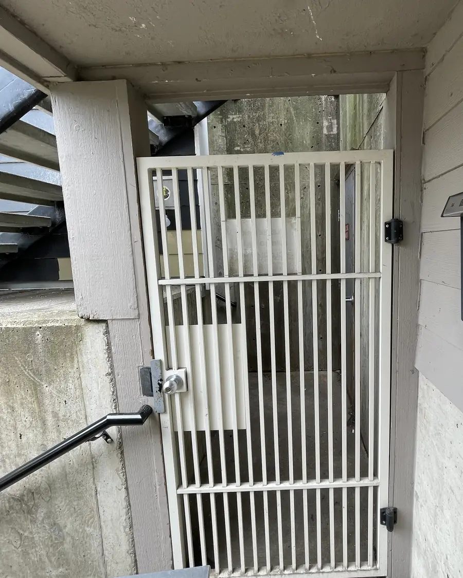 Old white bar security gate at an apartment building entry