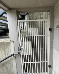 Old white bar security gate at an apartment building entry