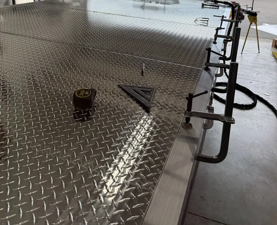New aluminum diamond-plate pontoon deck with clamps along the edge