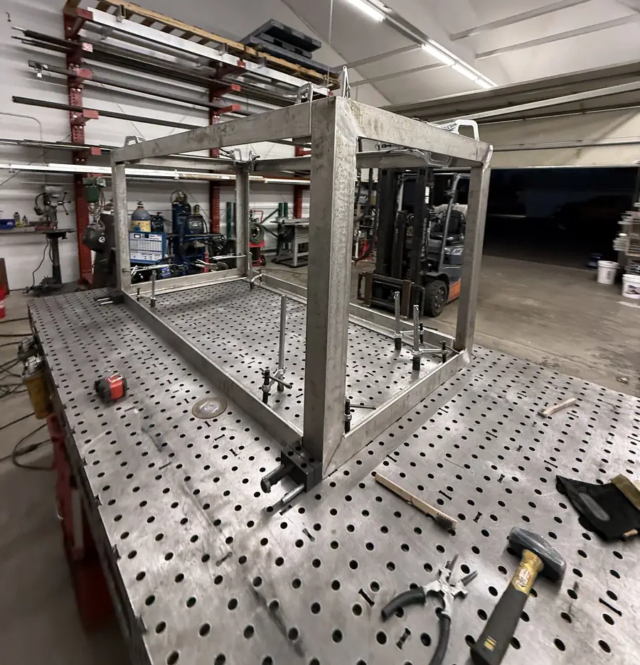 Stainless box frame tacked up on a fixture table in the shop