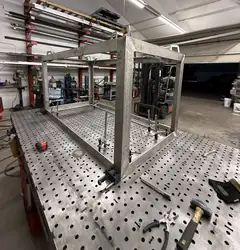 Stainless box frame tacked up on a fixture table in the shop